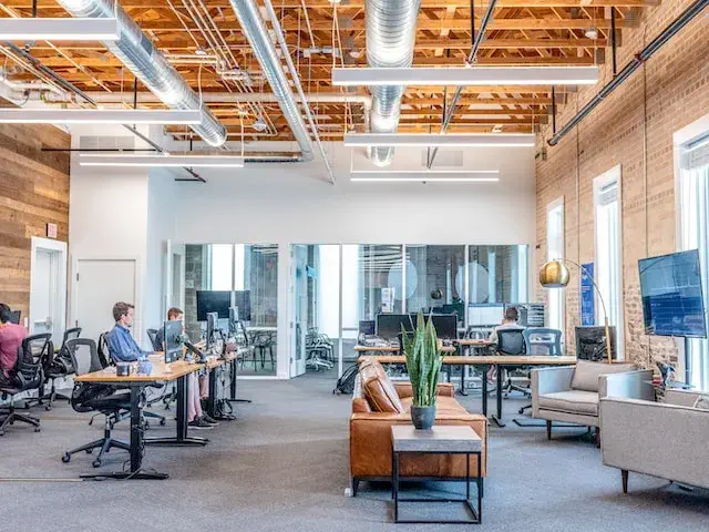A photo of a large office people with several people sat at desks